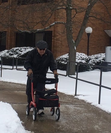 A man pushes the Drive Nitro rollator on a sidewalk
